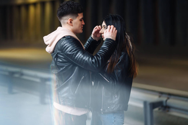 Young couple in love hug each other and have fun  in underground crossing. Couple of man and woman walking into a tunnel. Happy to be together. Love, romantic, passion, tenderness concept. - Fotoğraf, Görsel