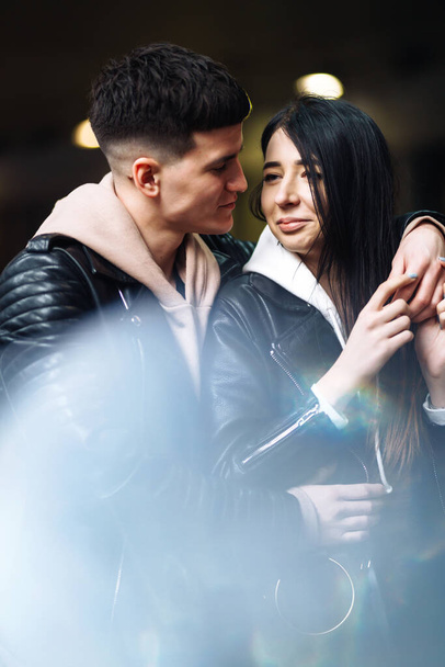 junges verliebtes Paar umarmt sich und hat Spaß beim U-Bahn-Überqueren. Mann und Frau gehen in einen Tunnel. glücklich, zusammen zu sein. Liebe, Romantik, Leidenschaft, Zärtlichkeit. - Foto, Bild