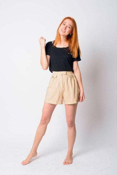 Full body shot of happy young beautiful redhead woman smiling - Photo, Image