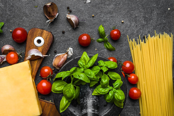 Italian food ingredients for spaghetti: parmesan, pasta, tomatoes, basil, garlic - Fotó, kép