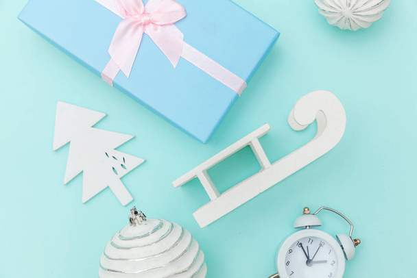 Simpelweg minimale samenstelling winter objecten ornament slee sparren boom bal geschenk doos geïsoleerd op blauw pastel trendy achtergrond - Foto, afbeelding