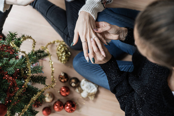 Lesbian couple getting engaged next to a Christmas tree - Photo, Image