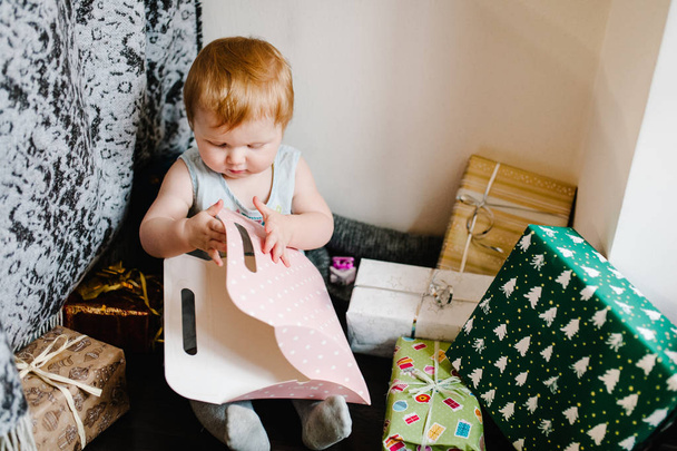 Mutlu küçük kız portresi hediyelerin arka planında oturuyor, neşeli doğum günü konsepti  - Fotoğraf, Görsel