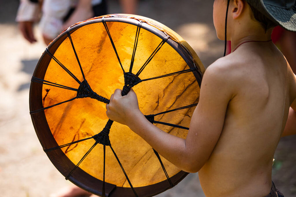 Kisgyerek játszik őshonos szent dob - Fotó, kép