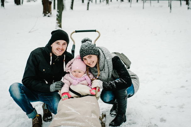 Mom, dad and daughter stand outdoors on the background winter - Photo, Image