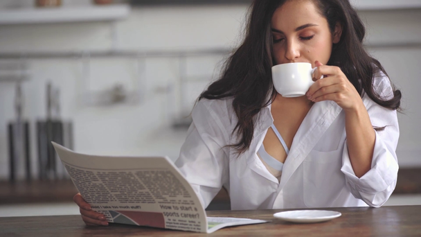 Frau liest Zeitung und trinkt Kaffee  - Filmmaterial, Video