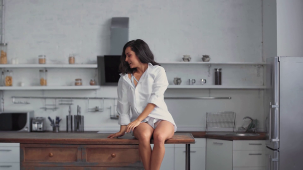 smiling woman sitting on wooden table  - Footage, Video