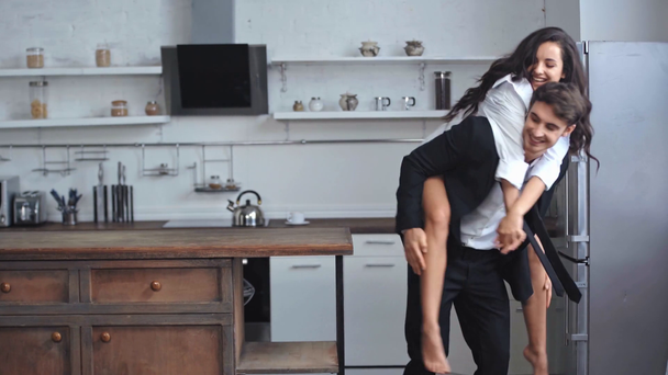 smiling girlfriend kissing and piggybacking businessman  - Footage, Video