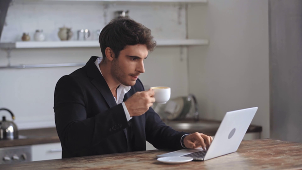 επιχειρηματίας χρησιμοποιώντας φορητό υπολογιστή και πίνοντας καφέ  - Πλάνα, βίντεο