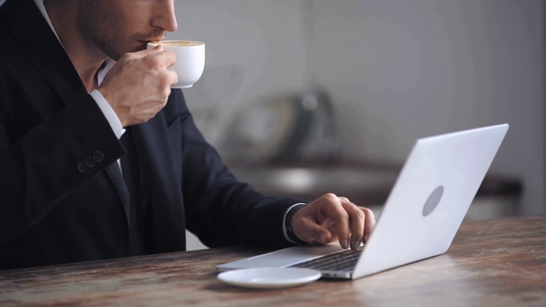 cropped view of businessman typing and drinking coffee  - Footage, Video