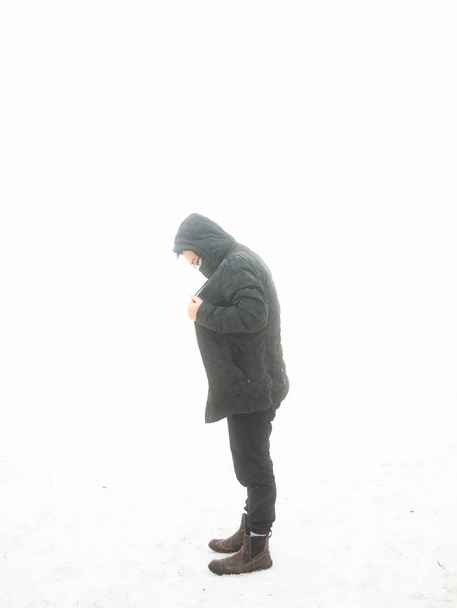 Muž v teplém saku v zimním zasněženém dni. Osamělý ve sněhu. Studená sezóna - Fotografie, Obrázek