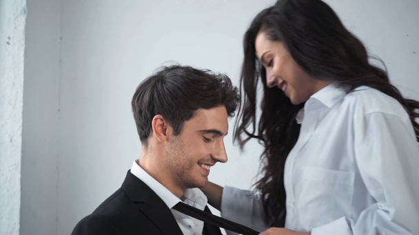 glimlachende vrouw knuffelen en houden stropdas van zakenman  - Video