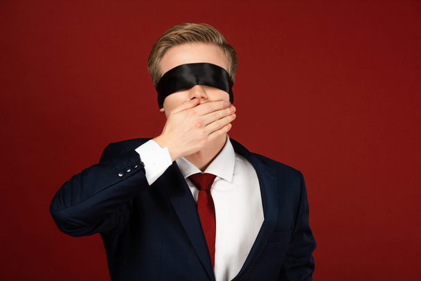 férfi bekötött szemmel szemfedő száj kezét piros háttér - Fotó, kép