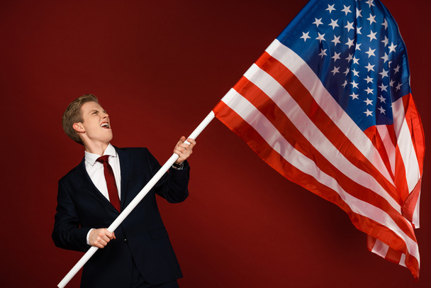 érzelmi férfi gazdaság amerikai zászló piros háttér - Fotó, kép