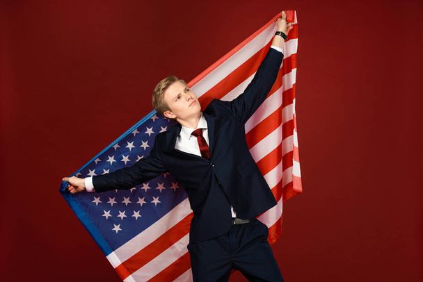 álmodozó férfi kezében amerikai zászló piros háttér - Fotó, kép
