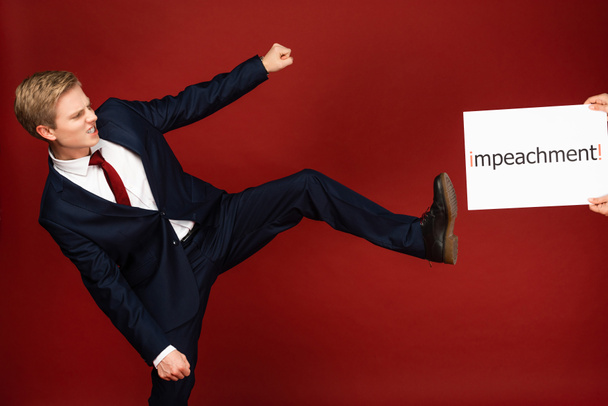 érzelmi férfi nyomja a lábát fehér kártya felelősségre vonás felirat piros háttér - Fotó, kép
