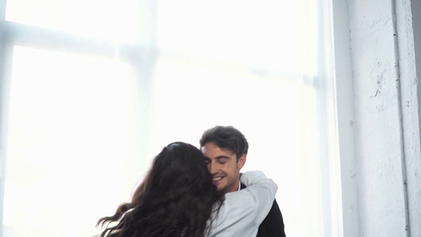 επιχειρηματίας αγκαλιάζει την κοπέλα του και την σπρώχνει στο κρεβάτι  - Πλάνα, βίντεο