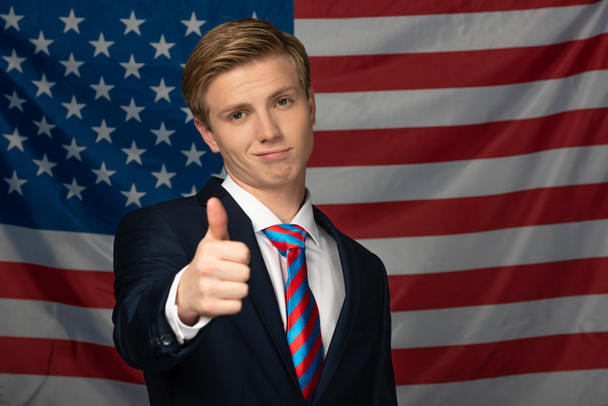 hombre mostrando el pulgar hacia arriba en fondo de la bandera americana
 - Foto, Imagen