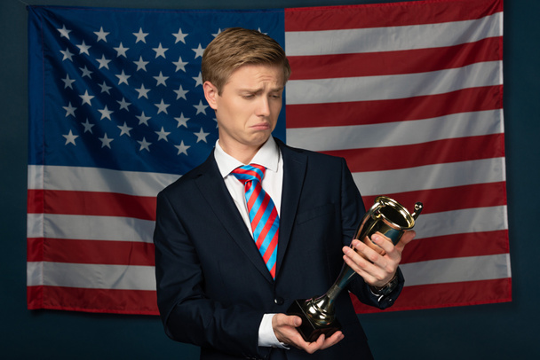 Mann mit goldenem Kelch auf amerikanischem Flaggenhintergrund - Foto, Bild