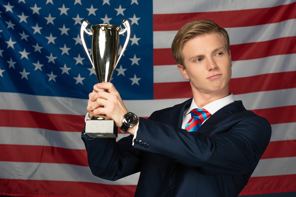 man holding golden goblet on american flag background - Photo, Image