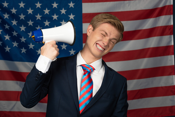 homme criant en mégaphone sur fond de drapeau américain
 - Photo, image