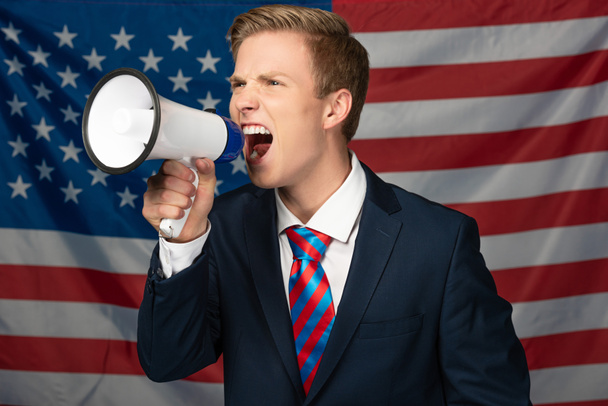 férfi kiabál megafon amerikai zászló háttér - Fotó, kép