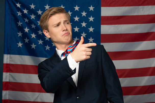 hombre señalando con el dedo en el fondo de la bandera americana
 - Foto, Imagen