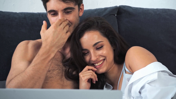 smiling boyfriend and girlfriend using laptop  - Кадри, відео