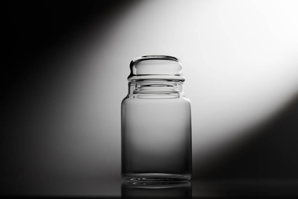 Empty glass jar on a black and white background - Foto, Imagen