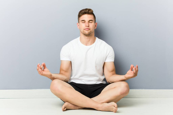 Молодой кавказский человек практикующий йогу, медитацию
. - Фото, изображение