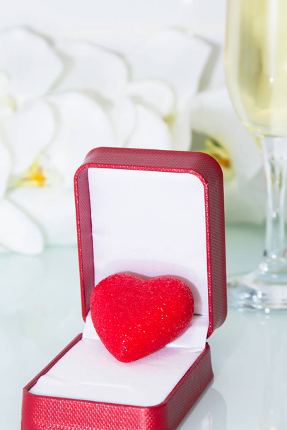 gift box with red heart with flowers and glass of champagne background, valentines day - Photo, image