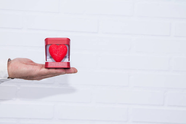 Tarjeta de felicitación del día de San Valentín, caja de mano de hombre con corazón
 - Foto, imagen