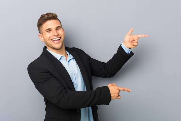 Young handsome caucasian man excited pointing with forefingers away. - Photo, image