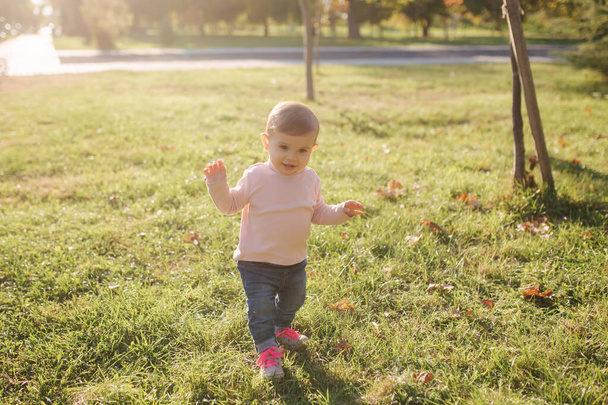 Imádnivaló kislány sétál az udvarban őszi időben. Boldog kislány. - Fotó, kép
