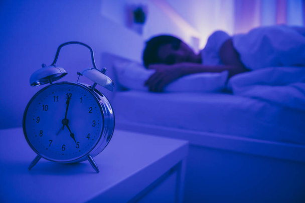 Close-up view of alarm call bell clock nice attractive peaceful serene girl lying in bed covered by soft blanket fallen asleep healthy life regime in dark illuminated room house hotel flat - Photo, Image