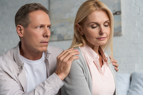 Man calming down worried wife at home - Photo, Image