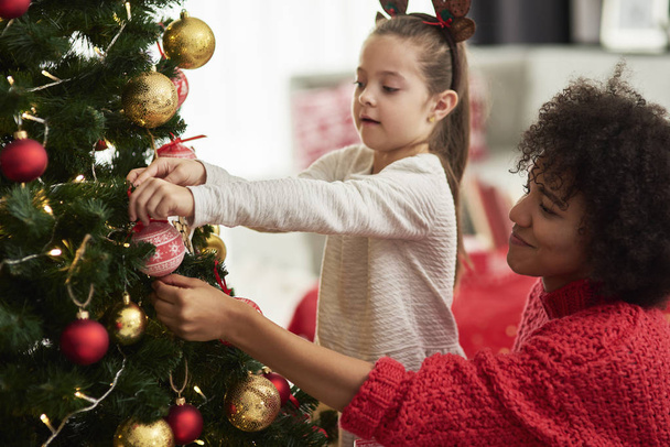 Charmant meisje en mam versieren kerstboom - Foto, afbeelding