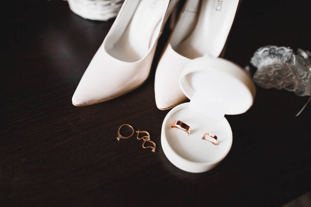 Beautiful toned picture with wedding rings and wedding shoes - Фото, изображение
