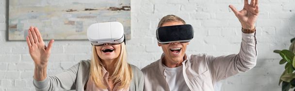 Panoramic shot of exited couple in virtual reality headsets - Foto, Bild