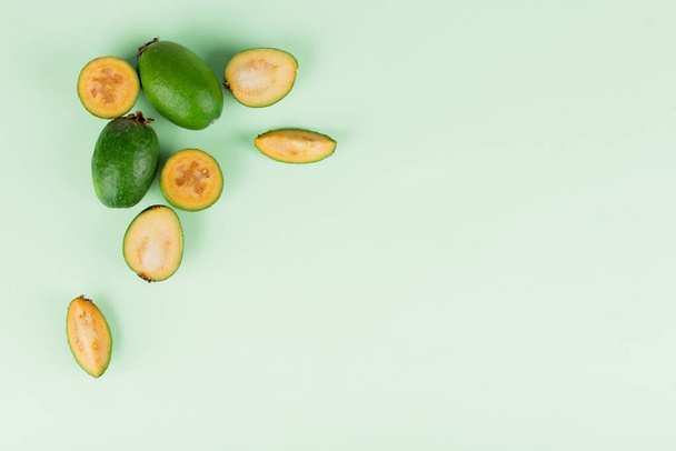 Nane arkaplanda dilimleri olan taze feijoa meyveleri. Meyve içeriği - Fotoğraf, Görsel
