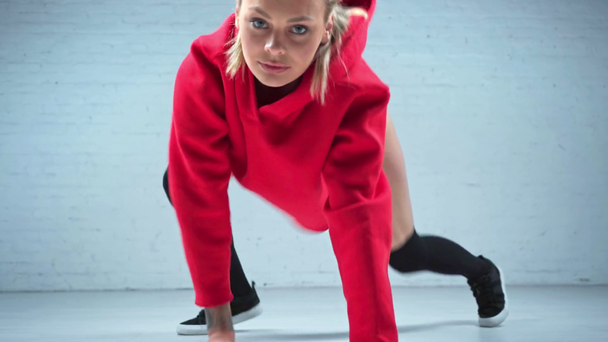 Szőke nő piros növény tetején táncoló twerk - Felvétel, videó