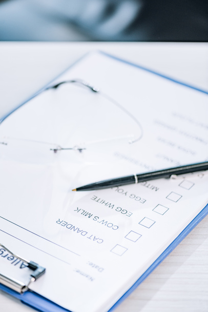 selective focus of pen near clipboard with checklist in clinic  - Фото, зображення