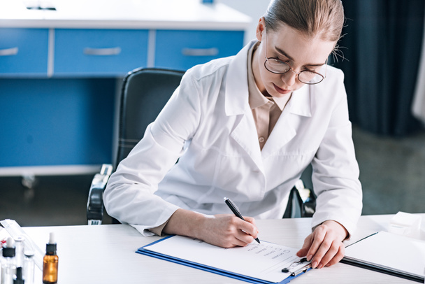 attractive allergist holding pen near clipboard with checklist  - Photo, Image