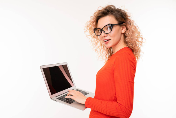 young woman in red dress posing with laptop against white background   - Foto, imagen