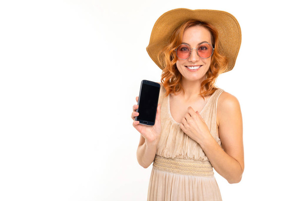 young woman in dress posing with mobile phone against white background   - Foto, afbeelding