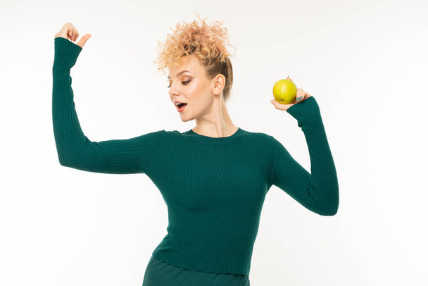 young woman in green dress posing with apple against white background   - Photo, Image