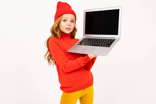 schattig meisje poseren met laptop in studio op lichte achtergrond  - Foto, afbeelding