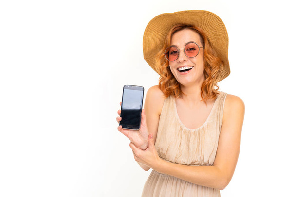молодая женщина в платье позирует с мобильного телефона на белом фоне
   - Фото, изображение