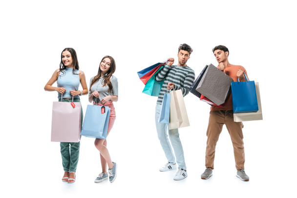 hermosos jóvenes amigos sosteniendo bolsas de compras con carteles de venta, aislados en blanco
 - Foto, imagen