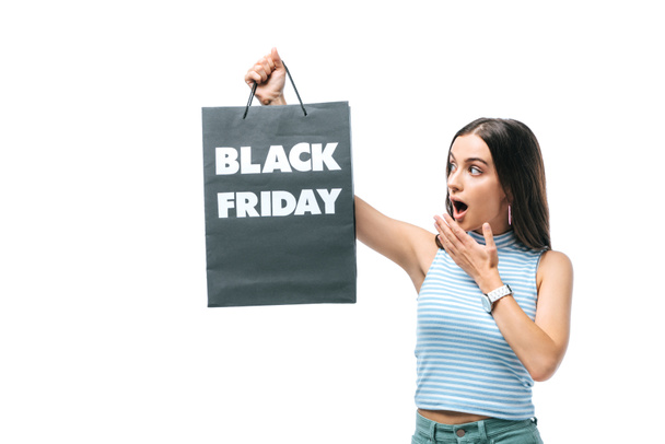 shocked woman holding shopping bag on black friday, isolated on white - 写真・画像